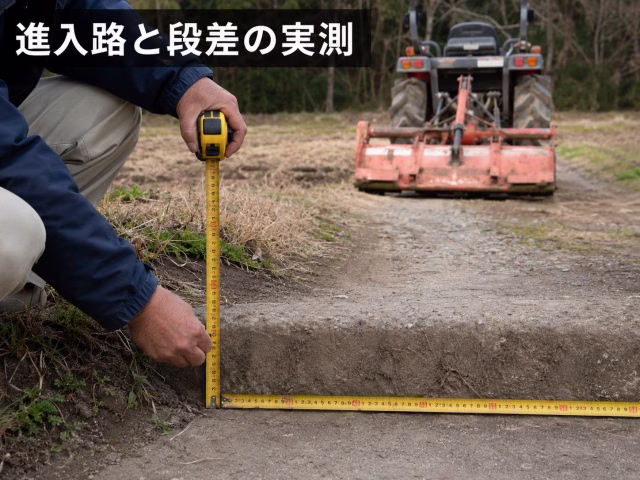 畑の進入路の幅と段差をメジャーで実測している様子
