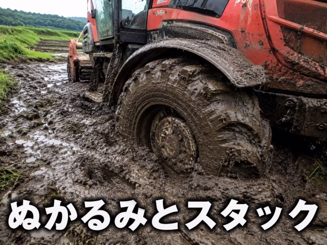 雨上がりのぬかるんだ粘土質の土壌でタイヤが深くスタックしているトラクター