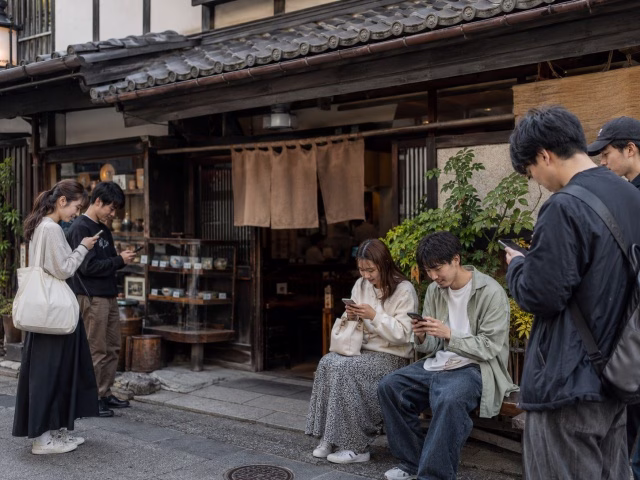地方の老舗飲食店とスマートフォンで店舗情報を見る若い世代のイメージ