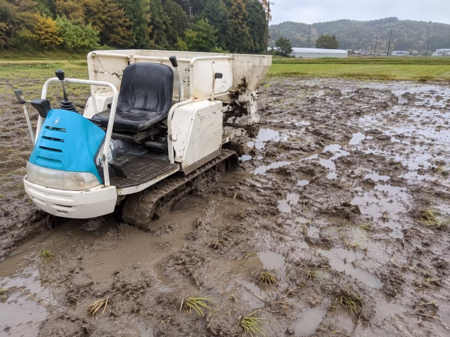 ぬかるんだ休耕田で車両のタイヤが沈んでいる様子